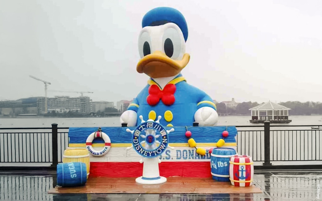 Donald Duck statue at Disneytown, Shanghai Disneyland, with waterfront view.