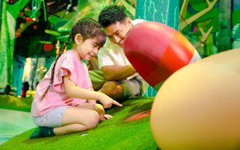 Child exploring interactive forest exhibit with adult in Forestland Curiosity Find.