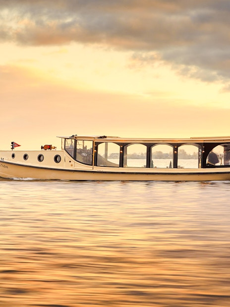 Amsterdam luxury boat on canal during sunset.