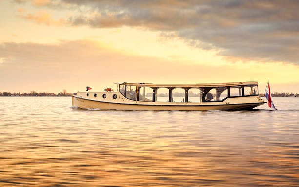 Amsterdam luxury boat on canal during sunset.