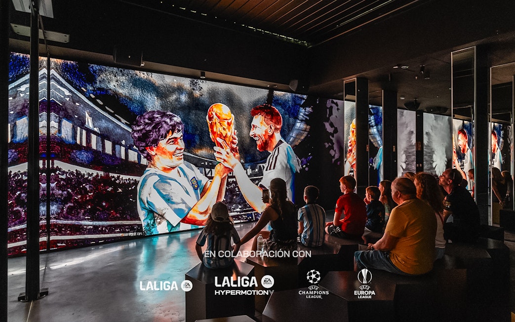 Visitors watching a football-themed digital display at Legends: The Home of Football Museum.