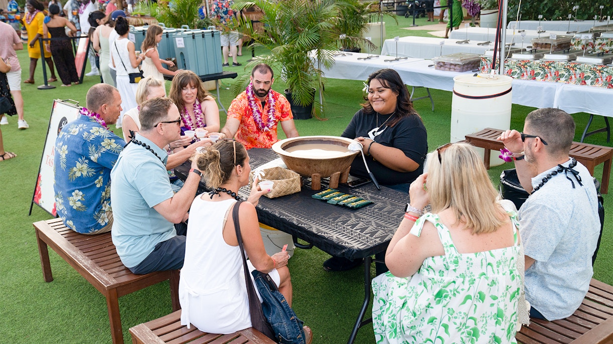 Guests sitting around during a food making activity at Mauka Warriors Luau