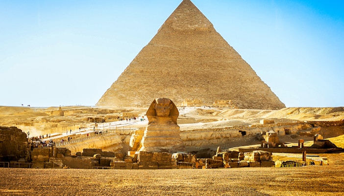 Pyramid of Giza and Sphinx with tourists exploring the site in Egypt.