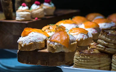 Salmon and crayfish tapas on bread slices, garnished with herbs.