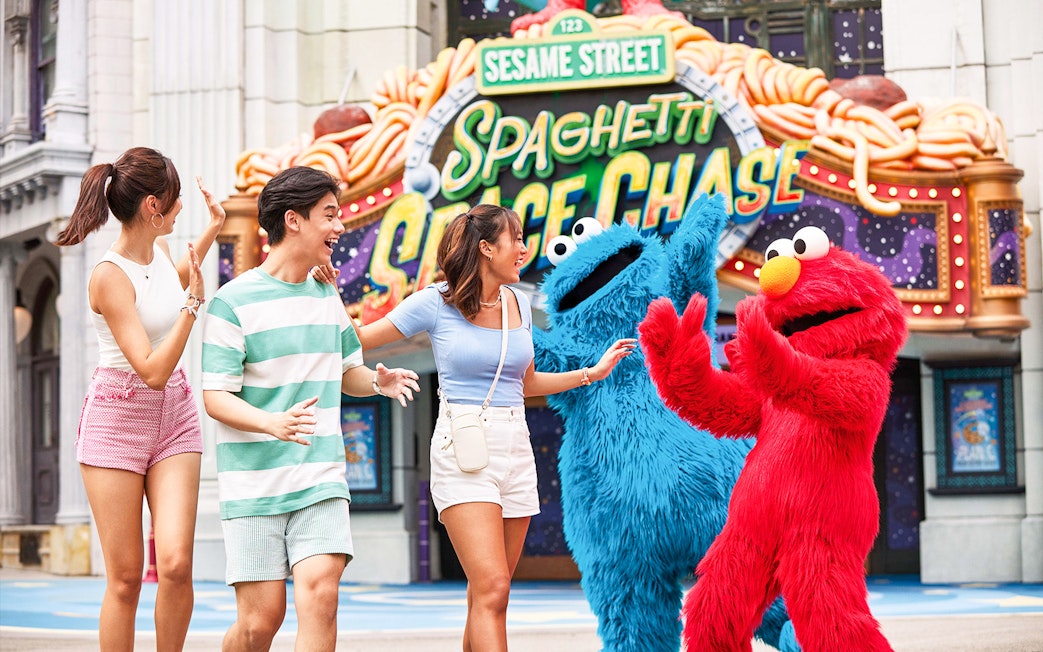Visitors interacting with Sesame Street characters at Universal Studios Singapore.