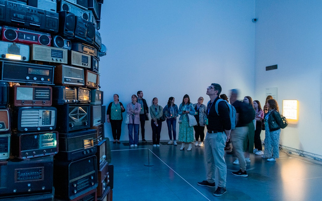 Visitors observing vintage radio installation at Tate Modern, London.