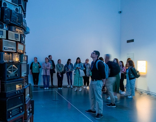 Visitors observing vintage radio installation at Tate Modern, London.