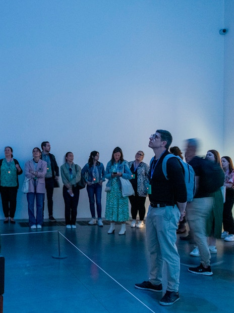 Visitors observing vintage radio installation at Tate Modern, London.