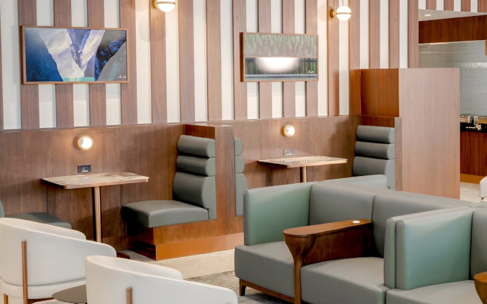 Seating area in Plaza Premium Lounge, Vancouver International Airport, featuring modern decor and private booths.