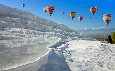 Hot air balloons over Pamukkale's travertine pools and limestone terraces, Turkey.