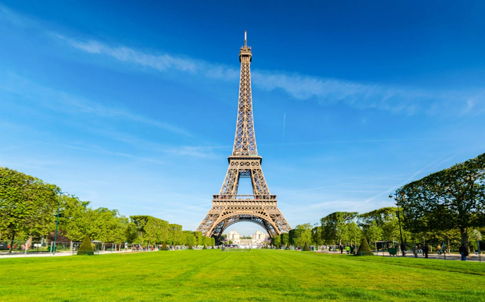 Eiffel Tower with surrounding gardens on a clear day, Paris walking tour.
