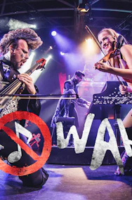 Musicians performing energetically on stage with WAH logo in foreground.
