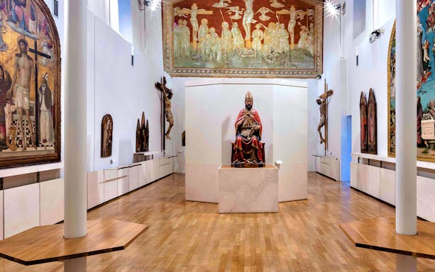 Museum of Brunello di Montalcino gallery with religious sculptures and frescoes.