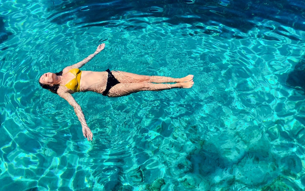 Guest floating in clear water during Blue Lagoon, Ciovo & Trogir Speedboat Tour.
