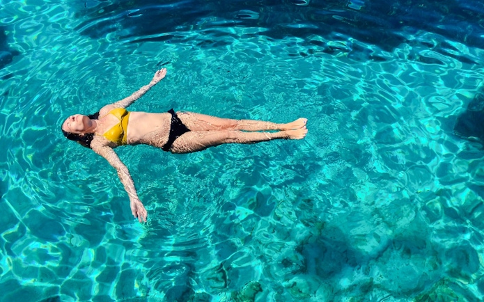 Guest floating in clear water during Blue Lagoon, Ciovo & Trogir Speedboat Tour.