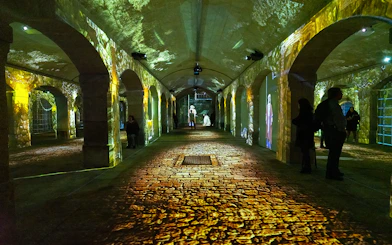 Porto Legends immersive experience with projections in a historic stone archway.