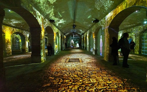 Porto Legends immersive experience with projections in a historic stone archway.