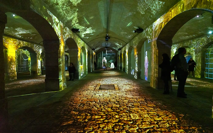 Porto Legends immersive experience with projections in a historic stone archway.