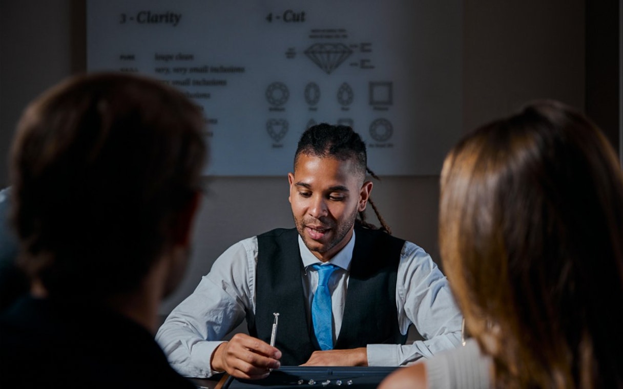 Guest examining diamond with expert at Royal Coster Diamond Experience, Amsterdam.
