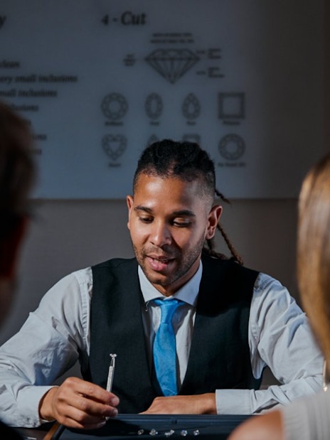 Guest examining diamond with expert at Royal Coster Diamond Experience, Amsterdam.
