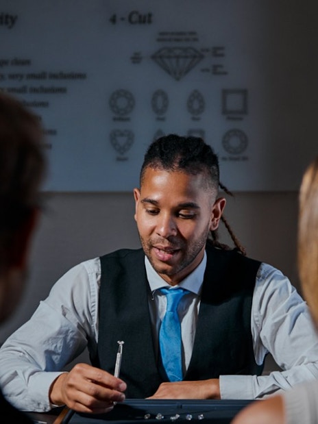 Guest examining diamond with expert at Royal Coster Diamond Experience, Amsterdam.