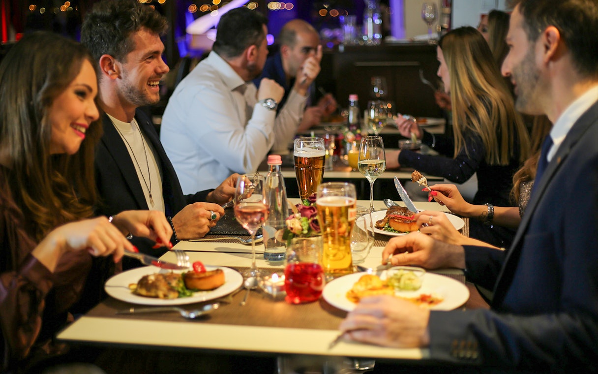 Guests dining on a Budapest dinner cruise with a piano battle show.
