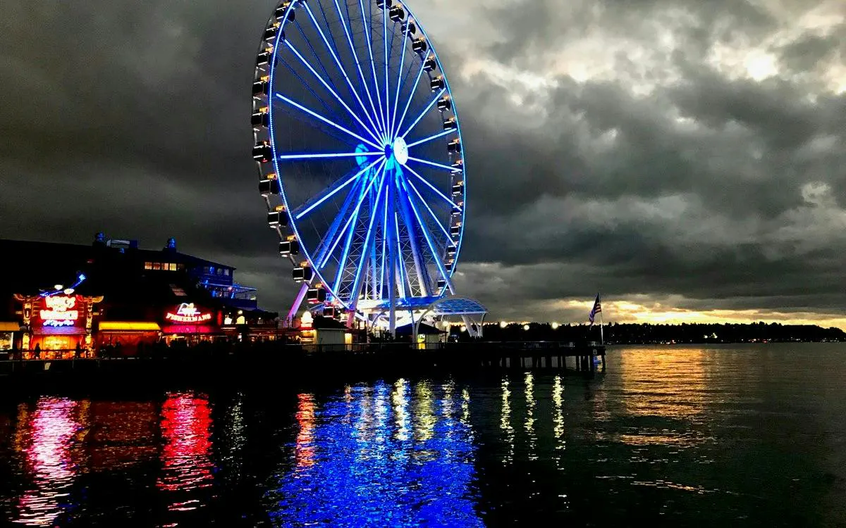 Seattle Great Wheel illuminated at night on the waterfront, part of the Harbor of Secrets game.