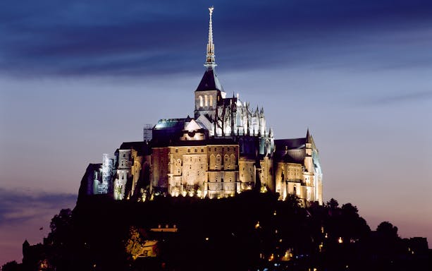 Mont Saint Michel Abbey illuminated at dusk, Normandy, France.
