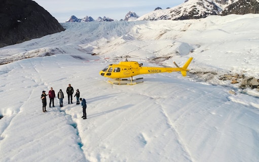 Helicopter on glacier with tourists during Juneau tour, Alaska.