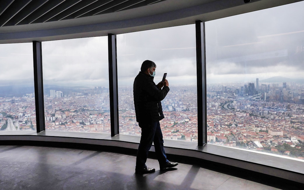 Person taking photo of Istanbul skyline from Çamlıca Tower observation deck.