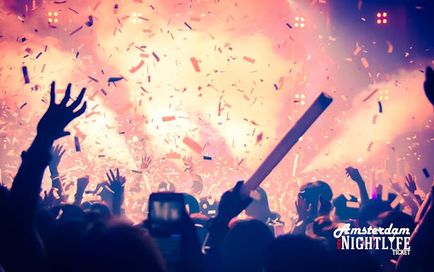 Crowd enjoying a vibrant night event with confetti in Amsterdam.