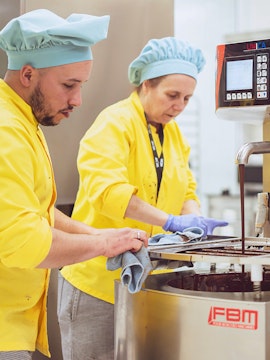 Chocolate makers working with machinery at The Chocolate Story Museum.