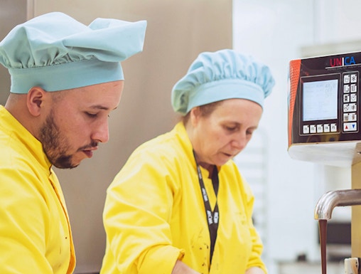 Chocolate makers working with machinery at The Chocolate Story Museum.