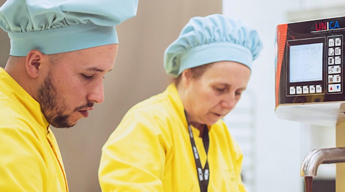Chocolate makers working with machinery at The Chocolate Story Museum.