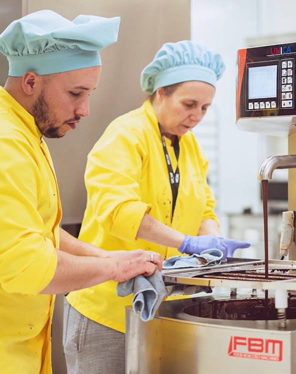 Chocolate makers working with machinery at The Chocolate Story Museum.