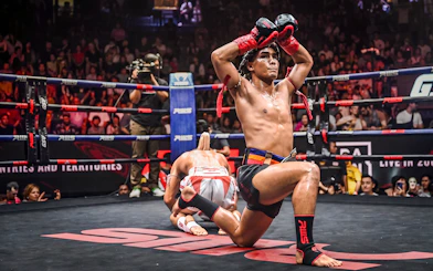 Muay Thai fighters in Rajadamnern Stadium, Bangkok, preparing for a match.