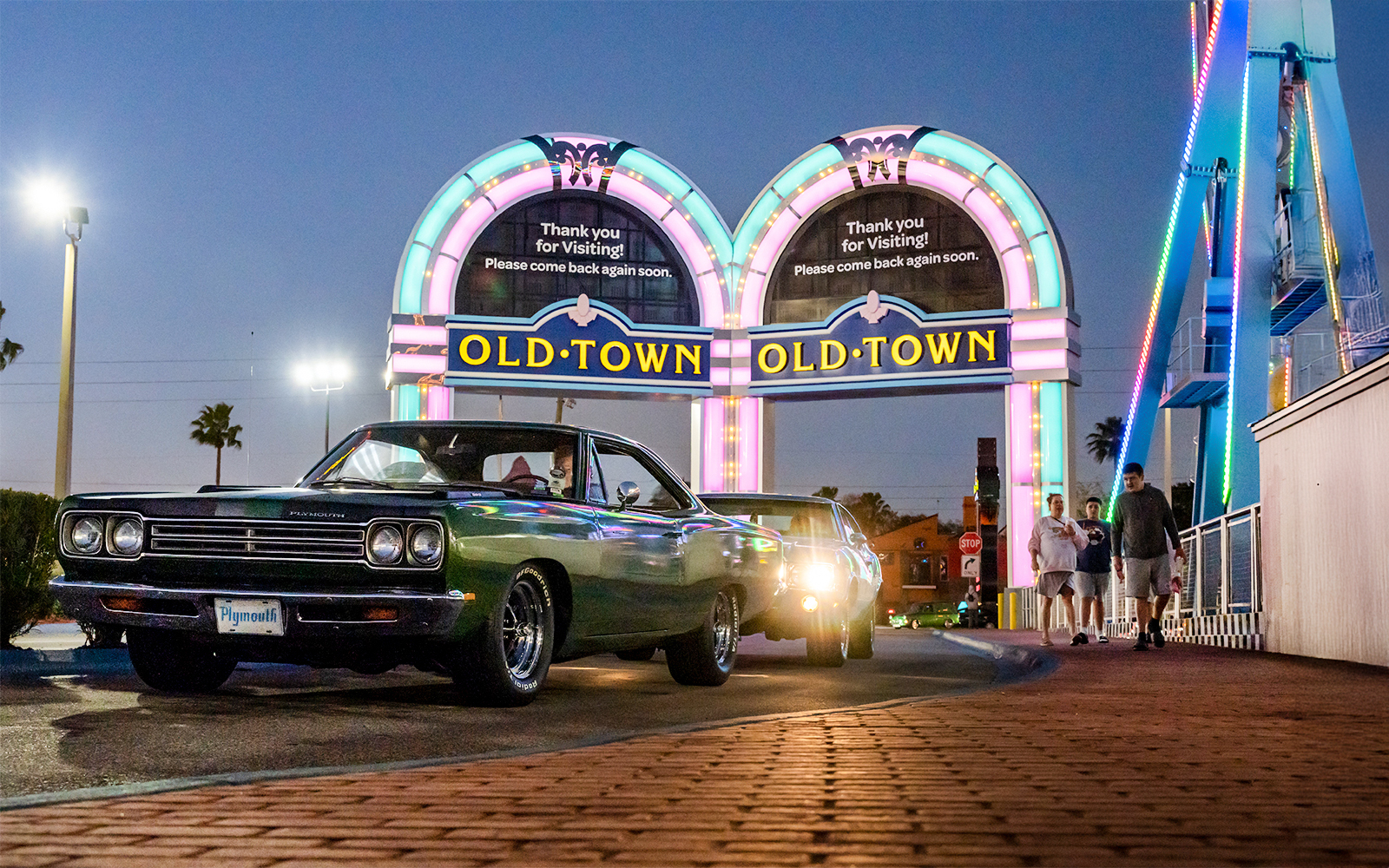 Classic cars under neon Old Town sign in Orlando at dusk.