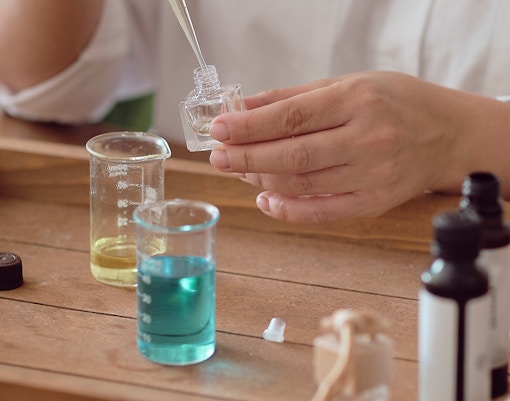 Perfume mixing at Perfume & Papyrus Workshop with beakers and dropper.