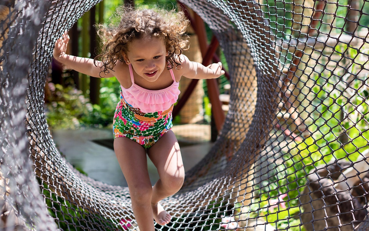 Child playing in net tunnel at Siam Park, Tenerife.