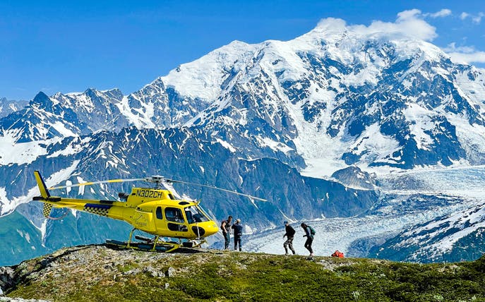 Helicopter on a glacier with tourists in Juneau, Alaska, during a dog sledding tour.