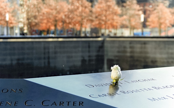 White rose on 9/11 Memorial names panel in New York City.