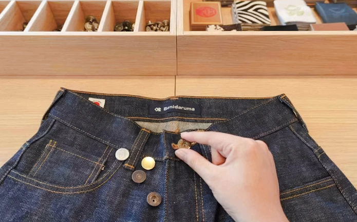 Hand selecting buttons for denim jeans at Harajuku, Tokyo experience.
