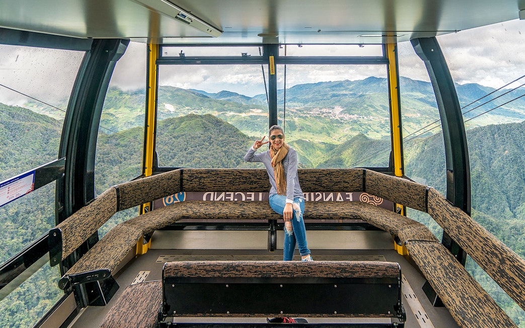 Visitor enjoying view inside Fansipan Cable Car at Sun World Fansipan Legend, Vietnam.