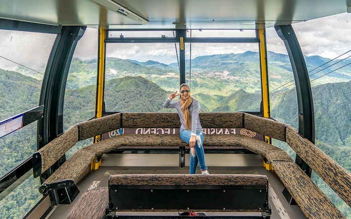Visitor enjoying view inside Fansipan Cable Car at Sun World Fansipan Legend, Vietnam.