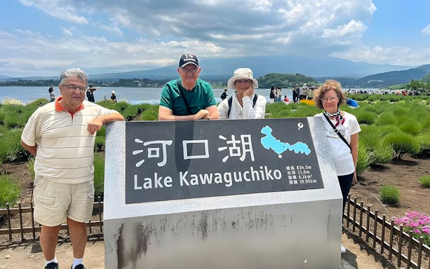 Lake Kawaguchiko sign with tourists, Mt Fuji in background, part of Hakone private van tour.