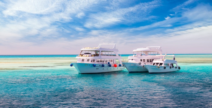 Cruise yachts on clear water near coral reef, Hurghada Sea trip.