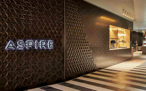Aspire Lounge entrance with geometric wall design at Schiphol Airport Terminal 2.