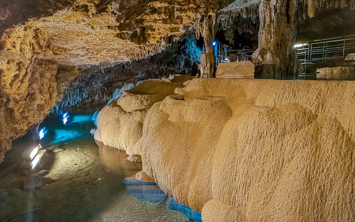 Underground limestone cave at Okinawa World with illuminated stalactites and stalagmites.