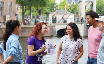 Tour guide with a group by a canal in Amsterdam on a SmallGroup Hidden Gems Tour.