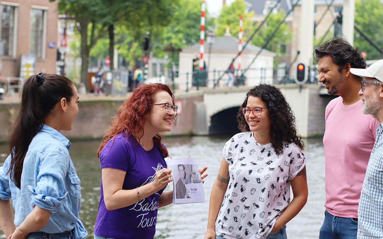 Tour guide with a group by a canal in Amsterdam on a SmallGroup Hidden Gems Tour.